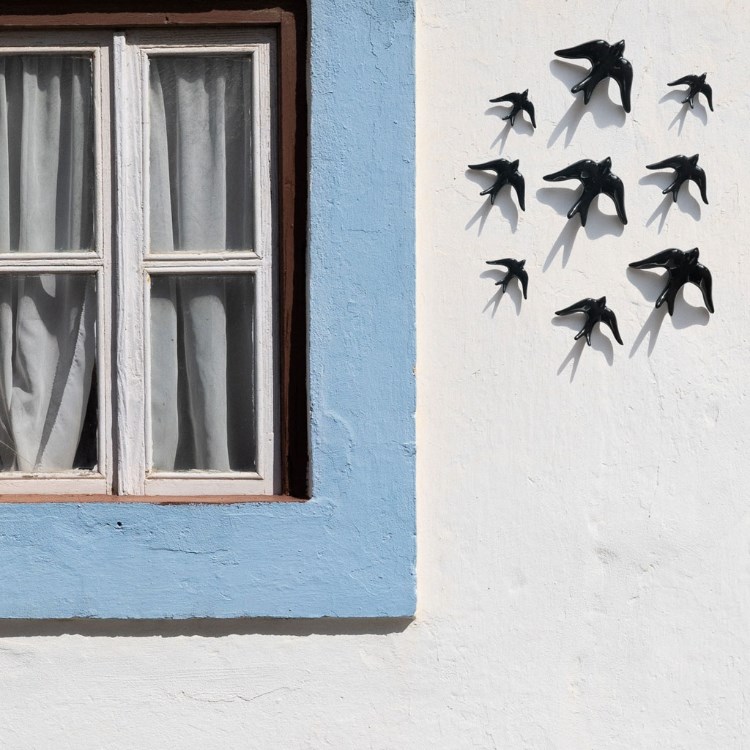 Black ceramic swallows in the wall